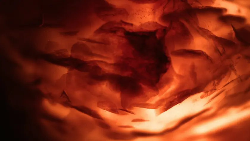 Texture abstraite aux nuances de rouge et orange, évoquant des formes organiques.